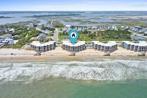 Un complejo turístico frente al mar con villas privadas en la playa, una playa arenosa y vistas al océano.