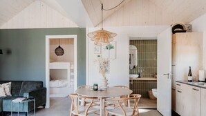 Una cocina moderna con armarios de madera, una mesa de comedor y un horno empotrado.