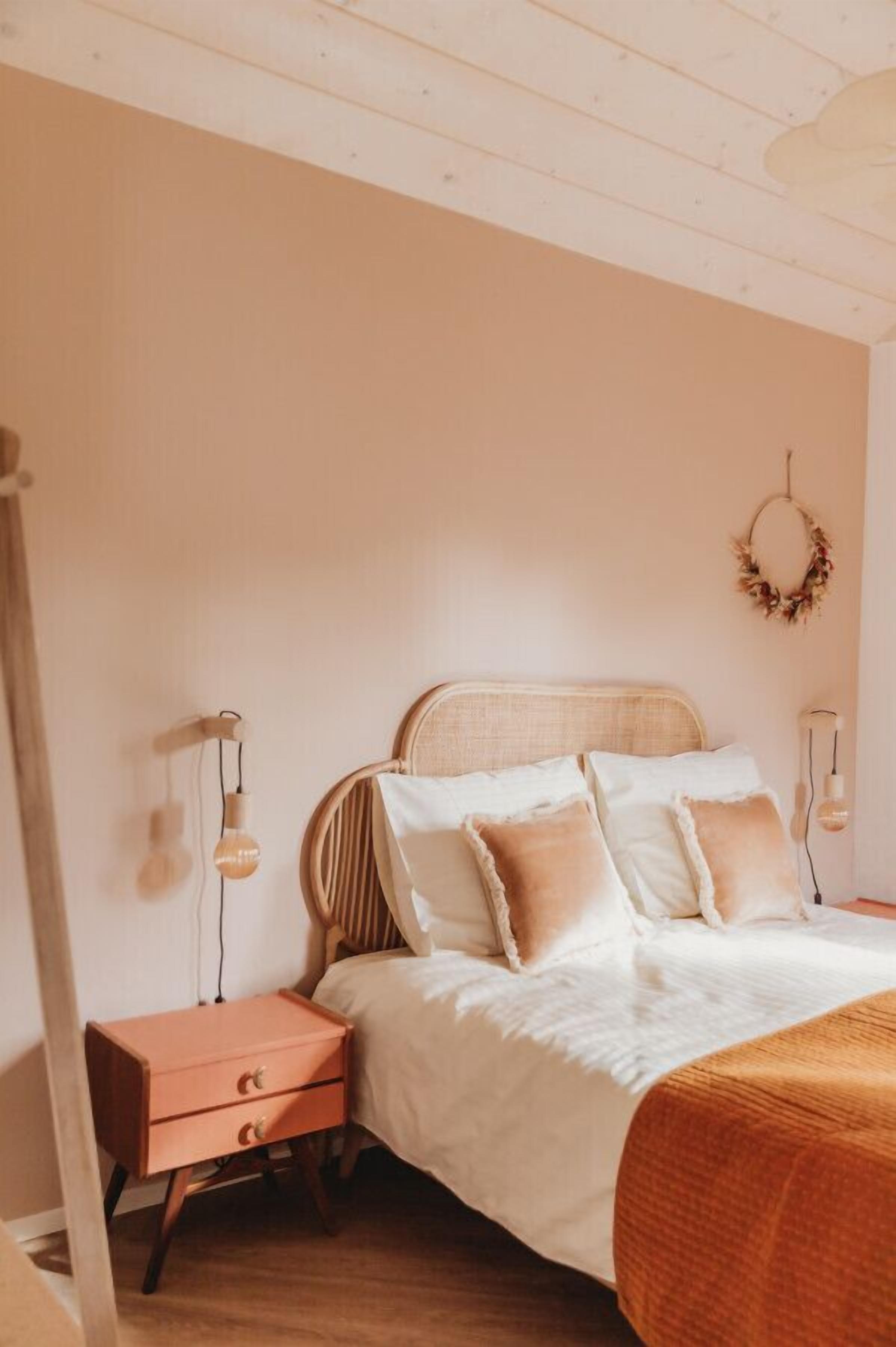 Una camera da letto con un letto, un comodino e lampade a parete.