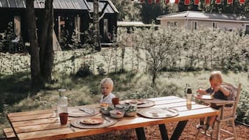 Un tavolo da picnic in legno all'aperto, con un bambino e un adulto.