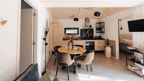 Une cuisine moderne avec un coin repas, des meubles en bois et une grande fenêtre.