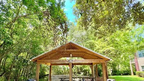 A covered picnic area with a wooden pavilion, picnic tables, and barbecue grills. - Luxury and comfy GS condo on the first floor. (Gulf Shores)