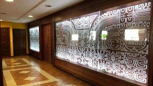 A hallway with patterned wall decor and a geometric floor design. - Prestige Lodging Papeete (Papeete)
