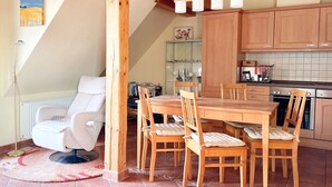Eine gemütliche Küche mit Holzschränken, einem Esstisch und Stühlen.