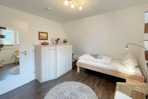 Una camera da letto con un letto, un comodino, una lampada e un armadio.