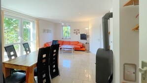 Un soggiorno moderno con zona pranzo, divano e televisione.