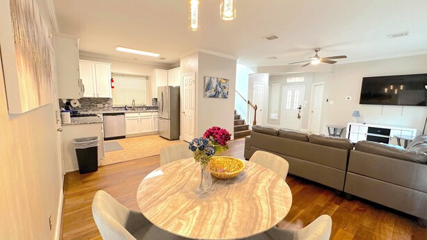 A modern living space with a kitchen, dining area, and a living room with a sofa and TV. - Spacious 5bed Houston Retreat Home
6 guests 4 bedrooms 5 beds 3 baths (Houston)