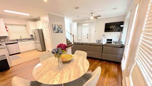 A modern kitchen with white cabinets, a dining table with chairs, a sofa, and a TV in the living area. - Spacious 5bed Houston Retreat Home
6 guests 4 bedrooms 5 beds 3 baths (Houston)