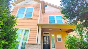 A two-story house with a brick foundation, a black front door, and a small porch area. - Spacious 5bed Houston Retreat Home
6 guests 4 bedrooms 5 beds 3 baths (Houston)