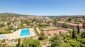 A residential area with a large swimming pool, surrounded by greenery and buildings. - Les Côteaux du Préconil by Interhome (Sainte Maxime)