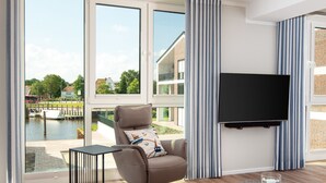 Un salon moderne avec une grande fenêtre, un canapé, un téléviseur et une petite table.