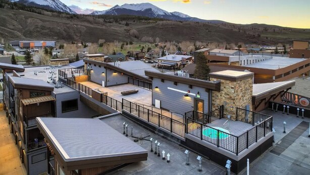 A modern building with multiple levels, including a rooftop area with a pool. - Blue River Parkway’s Colorful Escape (Silverthorne)