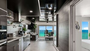 Una cocina moderna con vistas al océano, una zona de comedor con vistas, y un ventanal grande.