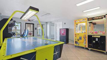 A pool table with a digital scoreboard, a toy chest arcade, and a vending machine.