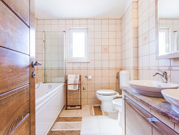 A bathroom with a bathtub, toilet, sink, and a shower.