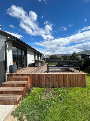 A modern house with a deck, a satellite dish, and a view of mountains. - Elevated Mountain Views on Waenga (Cromwell)