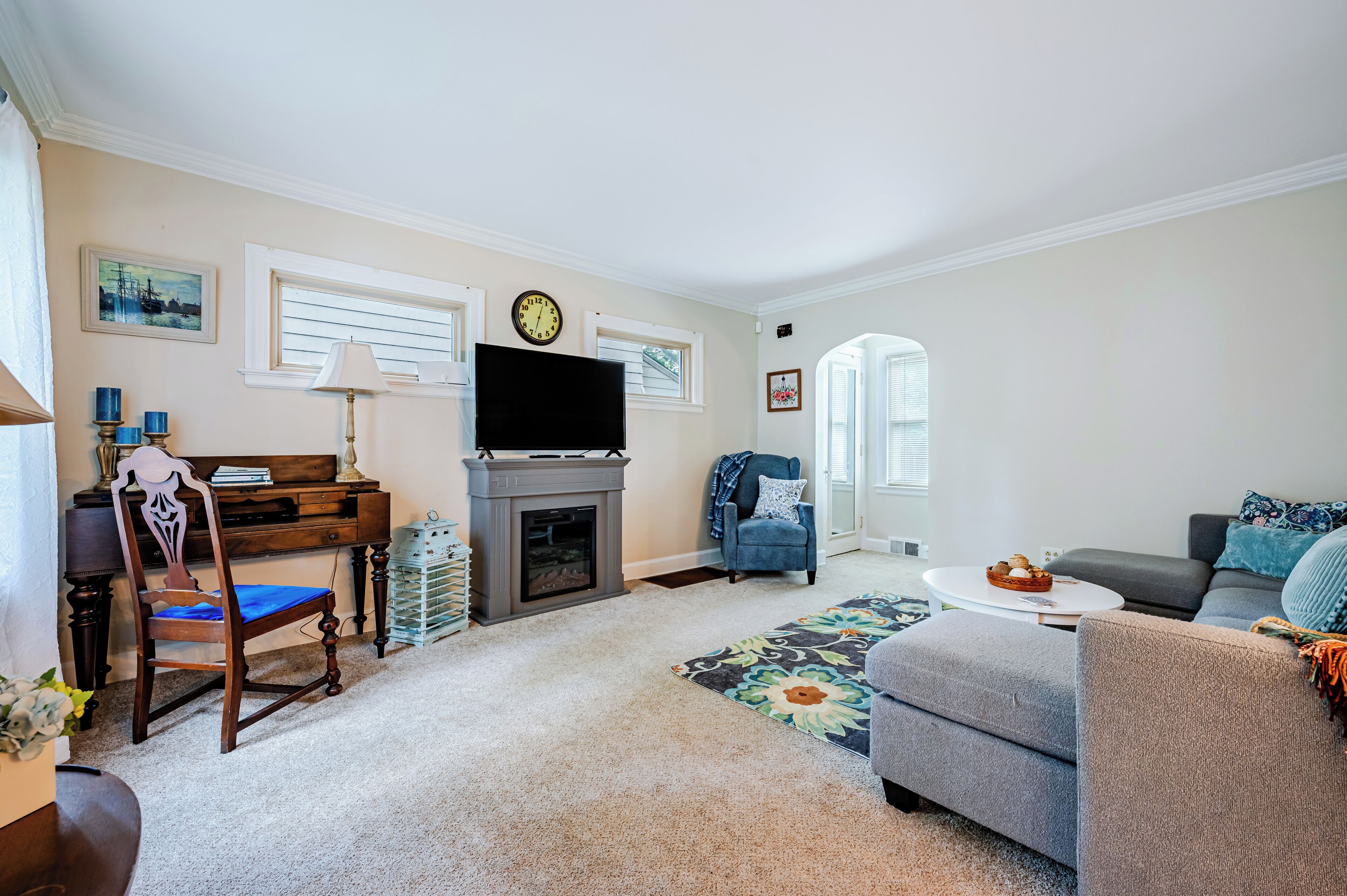 A living room with a fireplace, a television, a sofa, a chair, and a coffee table.