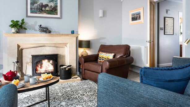 A living room with a fireplace, a sofa, a chair, and a coffee table.