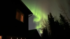 Una casa con un ventanal y vista al cielo nocturno.