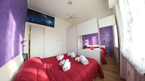 A modern hotel room with a red bed, a star ceiling light, and a purple wall. - Canova Accogliente Casa Vacanze - Affari (Milano)