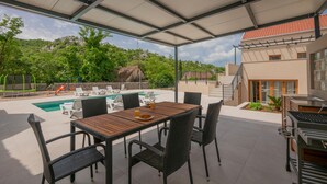 A covered outdoor area with a pool, lounge chairs, and a dining table. - Lovely home in Vrgorac with WiFi (Vrgorac)