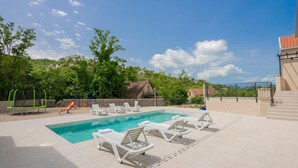 A pool area with lounge chairs, a slide, and a playground. - Lovely home in Vrgorac with WiFi (Vrgorac)