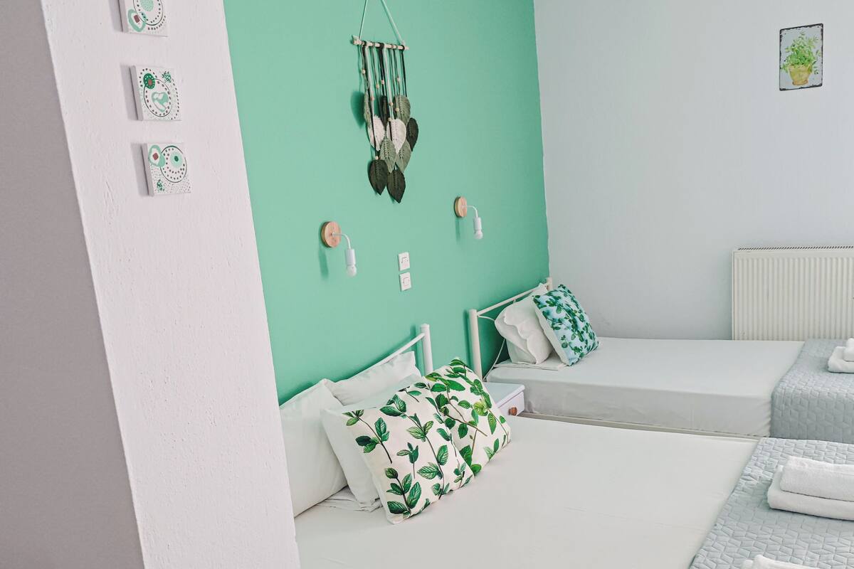 A room with two beds, a small table with a tray of items, and a wall with decorative elements.