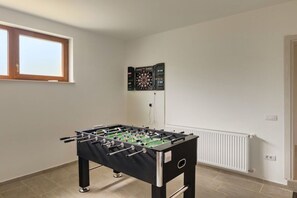 A room with a foosball table, a dartboard, and a window. - Villa Markulin Comfortable holiday residence (Pula)