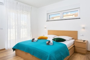 A bedroom with a bed, a nightstand, a window, and a curtain. - Luna & Pia Comfortable holiday residence (Pula)