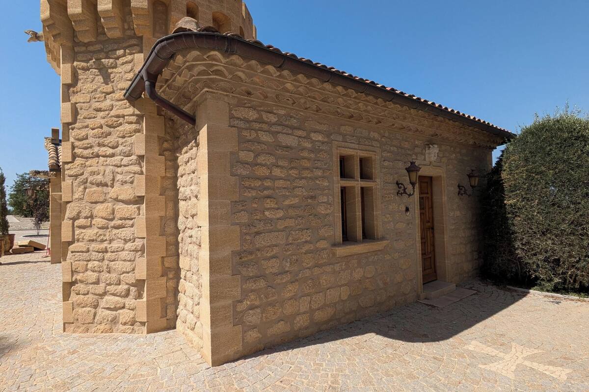 A stone building with a tower, a window, and a door.