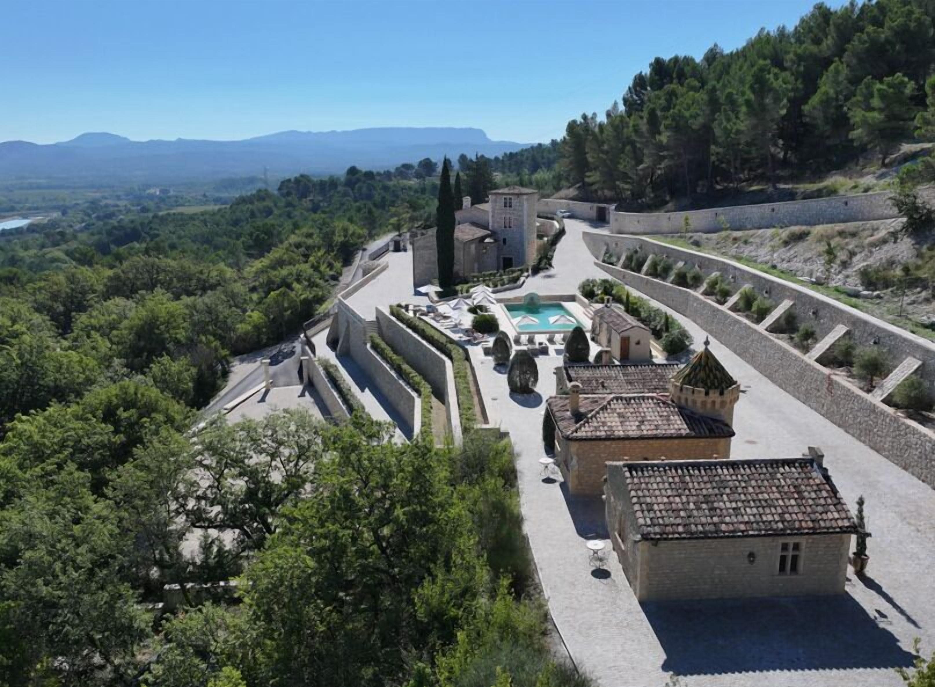 A fortified structure with a central courtyard, surrounded by walls and trees.