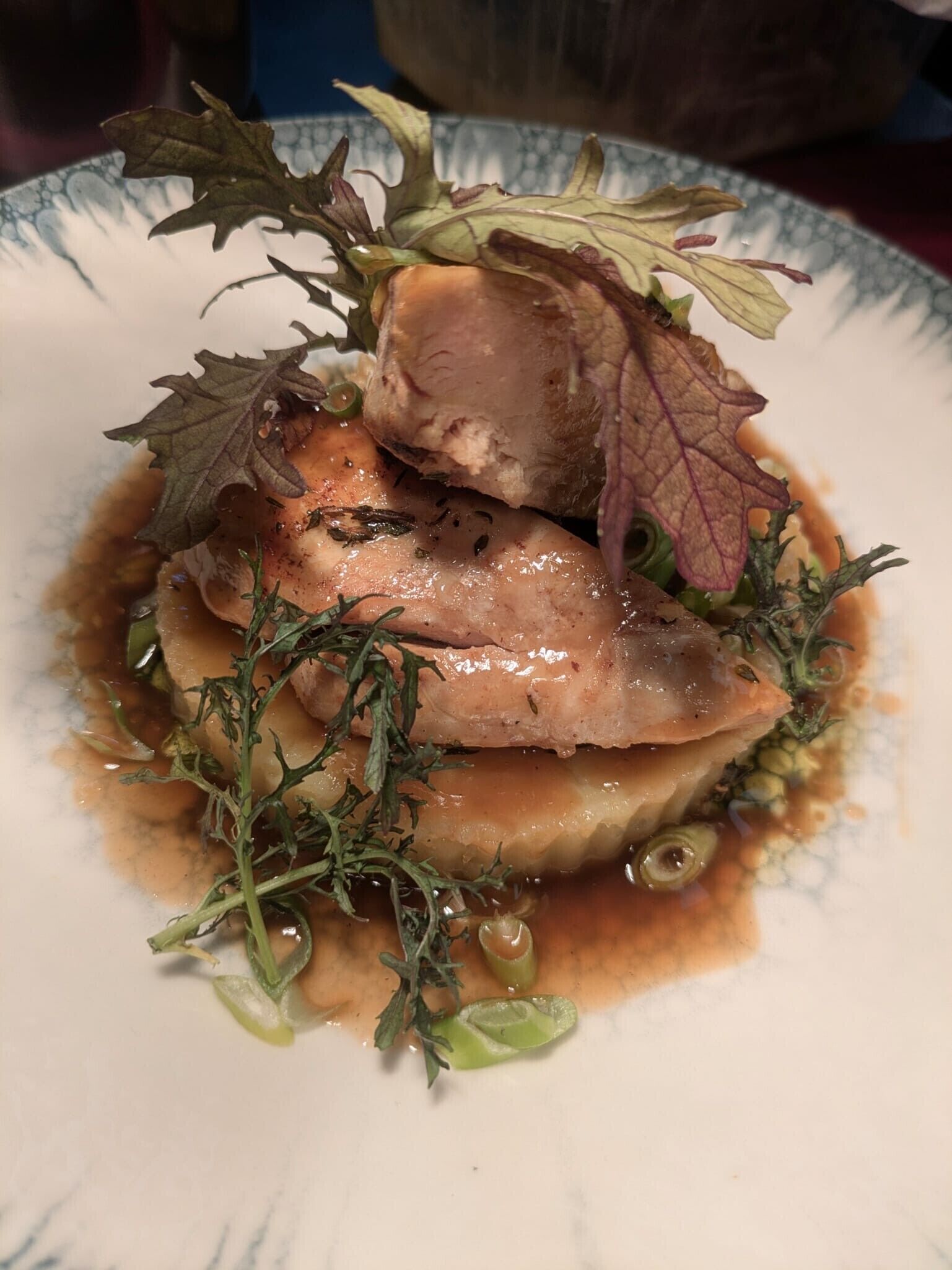 A plate of food with a variety of greens and a sauce.