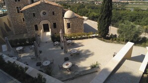 Un edificio in pietra con un cortile, posti a sedere all'aperto e vista sulla campagna.