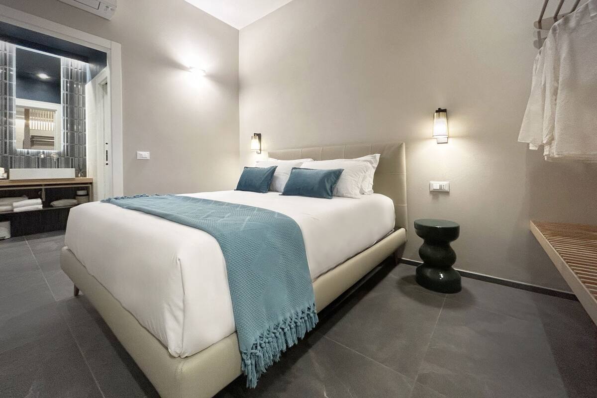 Une chambre moderne avec un grand lit, des lampes de chevet et une vue sur la salle de bain.