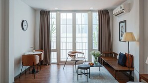 Una sala de estar moderna con comedor, ventanas amplias y un reloj en la pared.