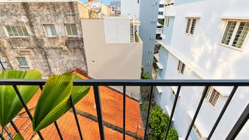 Un edificio de varios pisos con balcones, un patio con tejas rojas y una bandera en el tejado.