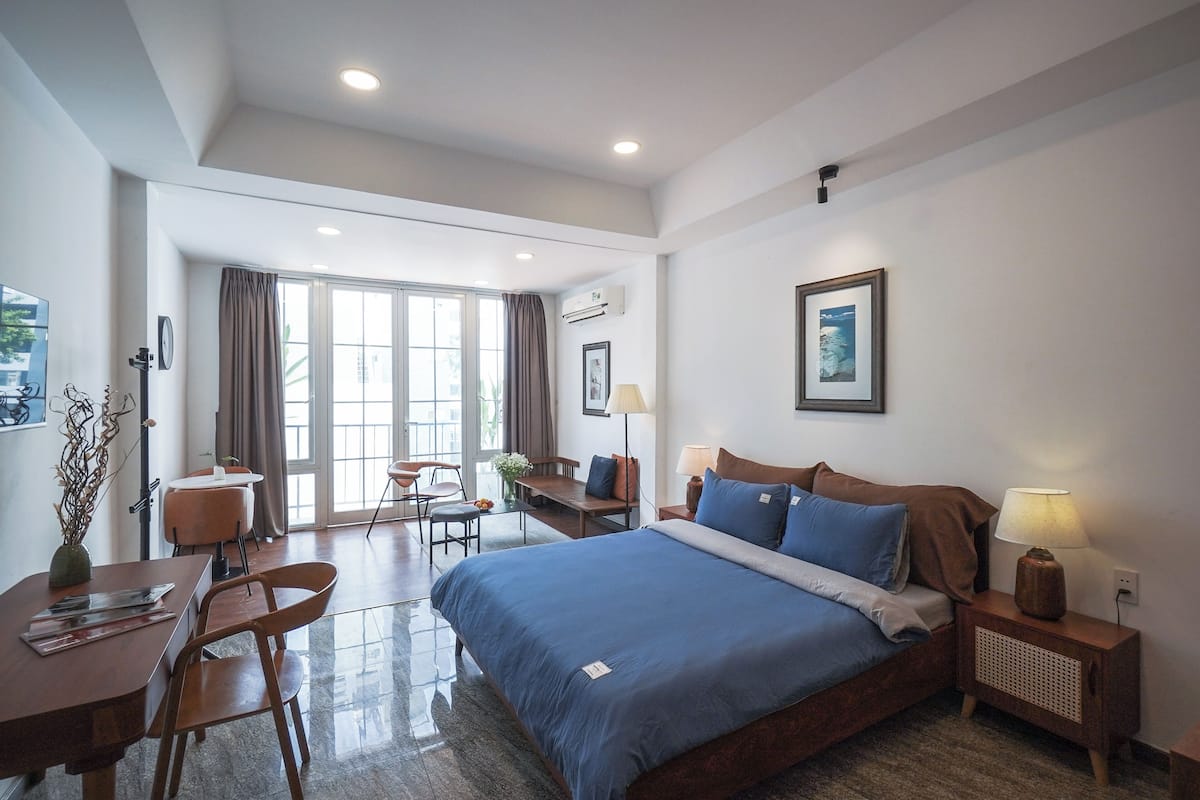 Una habitación de hotel con una cama grande, un escritorio, una silla y una mesa de comedor.