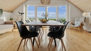 A spacious dining area with a high ceiling and large windows offering a view of the sea. - "Jolanta" - 20m from the sea by Interhome (Malling)