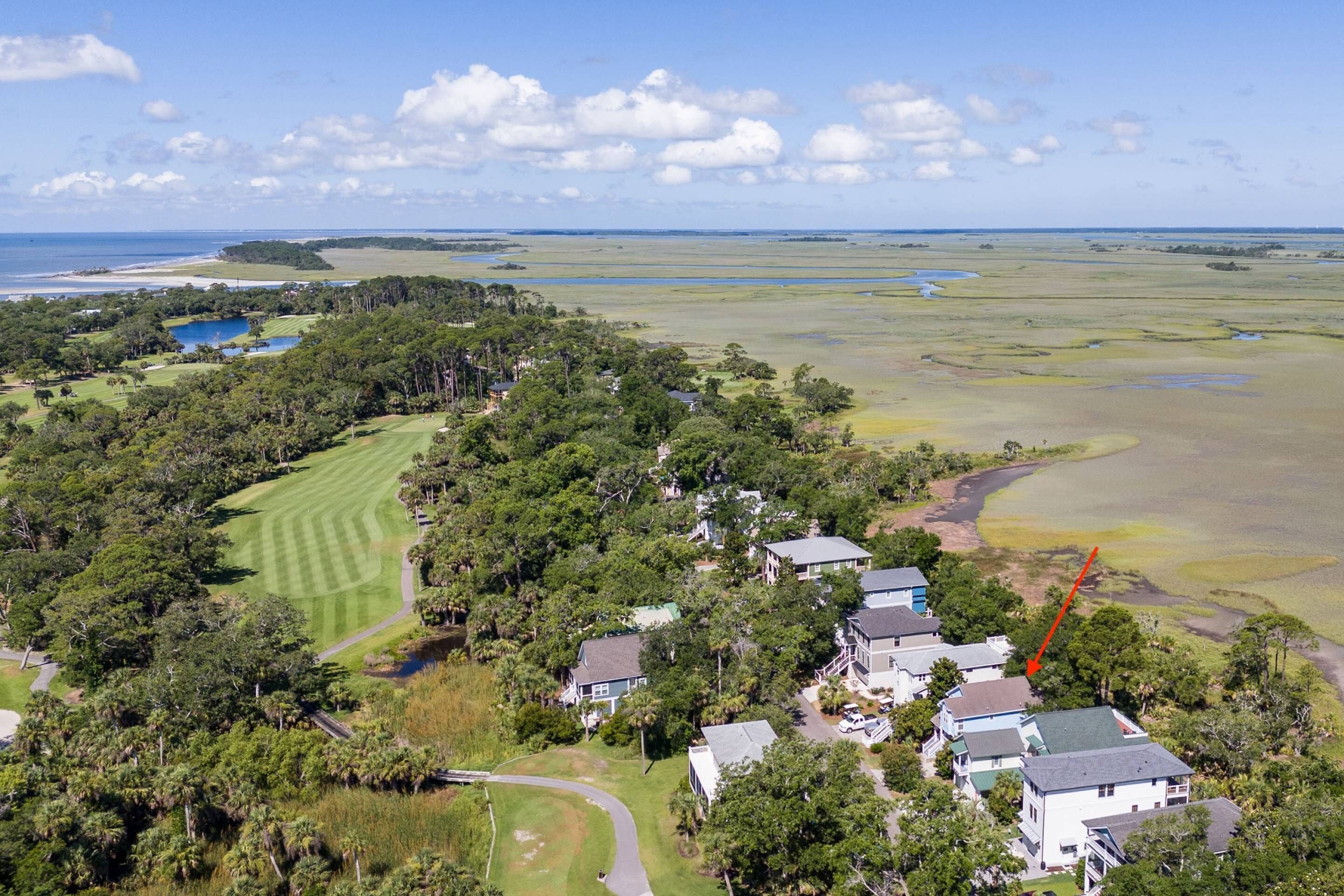 Un parcours de golf doté d’un club-house, entouré de propriétés résidentielles et de vastes champs ouverts.