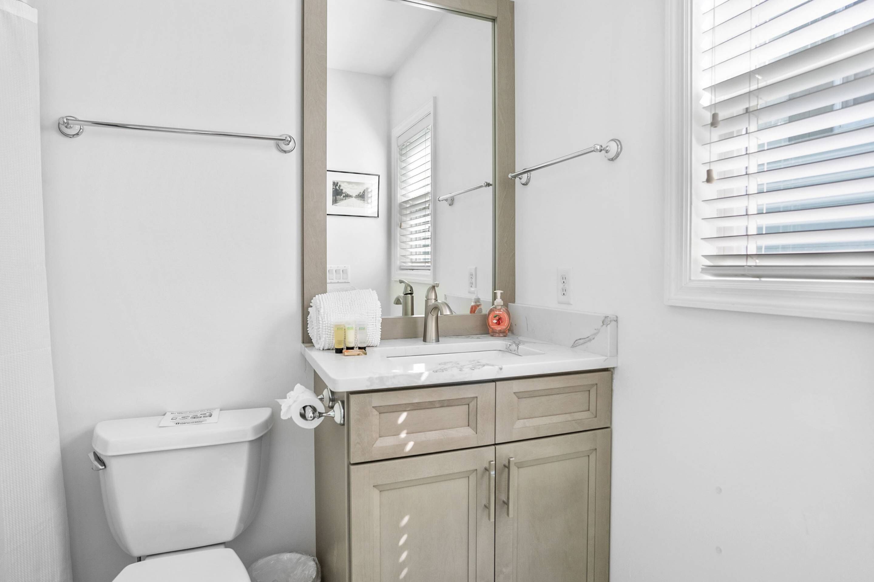 Une salle de bain avec des toilettes, un lavabo et un miroir.