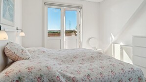 A bedroom with a bed, a window, and a radiator.