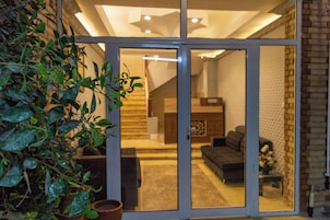 A modern interior with a sliding glass door leading to a living area with a sofa and a coffee table.