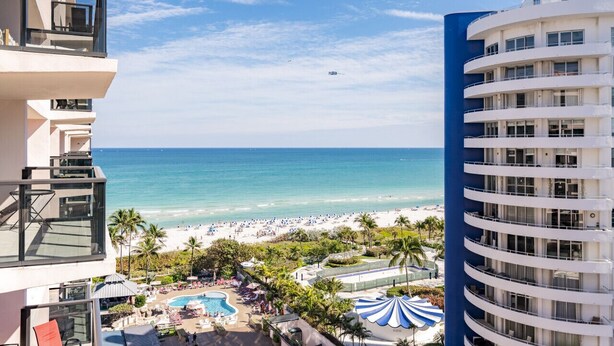 A hotel with a pool, beach view, and multiple balconies. - Luxury Beachfront Condo / Resort / 1415 (Miami Beach)