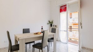 Un coin repas avec une table, des chaises et une bouteille de vin.