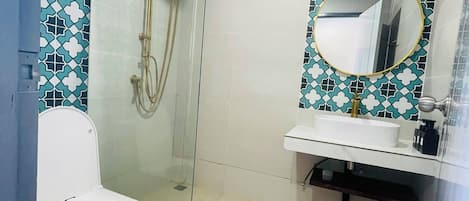 Une salle de bain avec des toilettes, une douche et un lavabo.