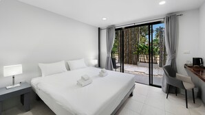 Quarto de hotel moderno com uma cama grande, uma escrivaninha e vista para o exterior.