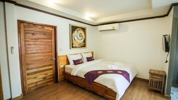 Un dormitorio con cama de madera, aire acondicionado de pared y puerta con diseño de paneles de madera.