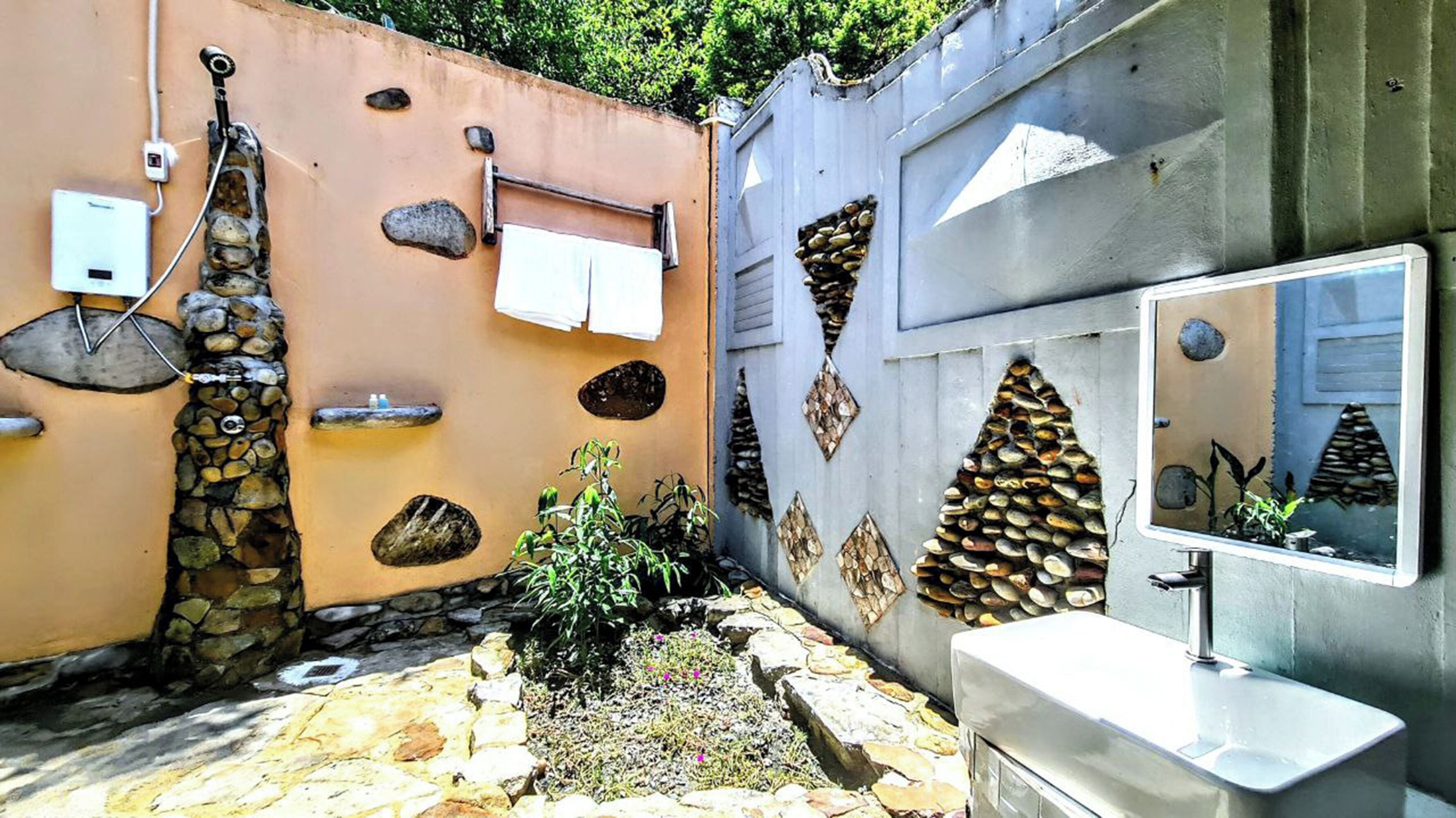 A bathroom with a stone wall, a sink, and a mirror.