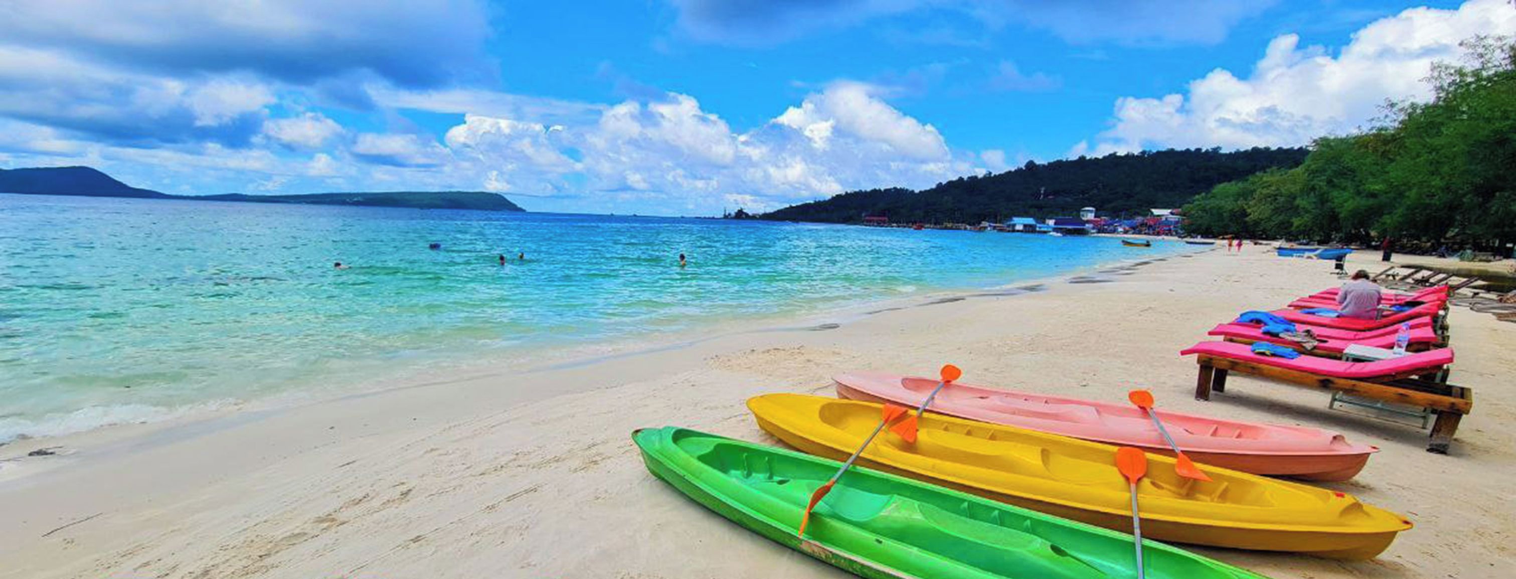 Una playa con kayaks y tablas de remo, y se lee el texto 