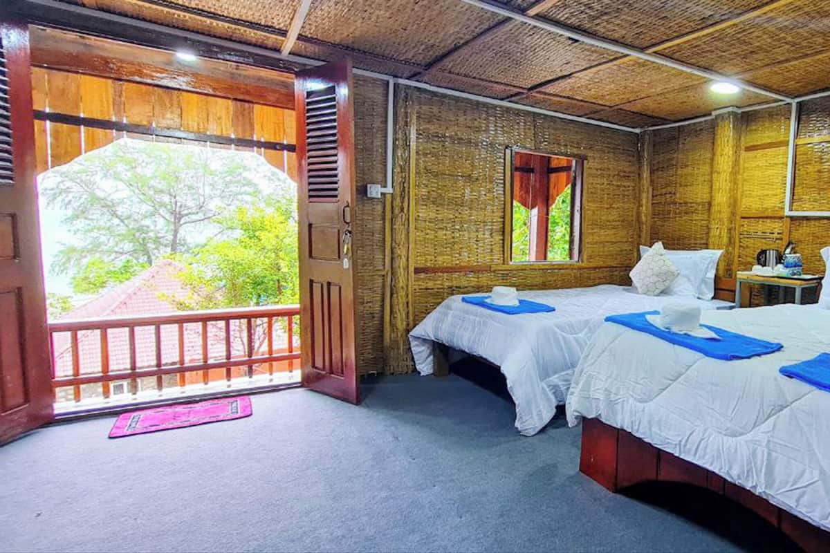 A room with two beds, a window, and a door leading outside.